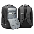 Dark charcoal gray anti-theft travel backpack 15.6 inch showing front and back with USB port visible on side, white background e-commerce photo